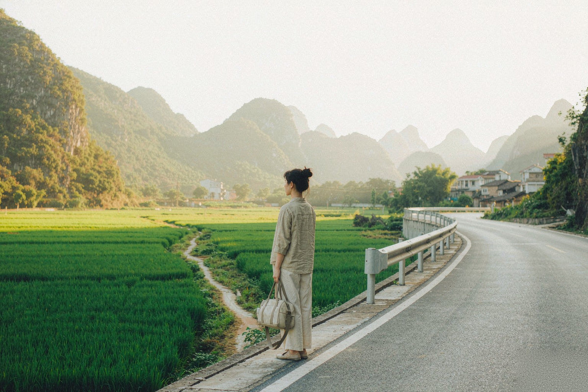 A quiet country road out of Guangzhou at golden hour — rice fields and karst hills